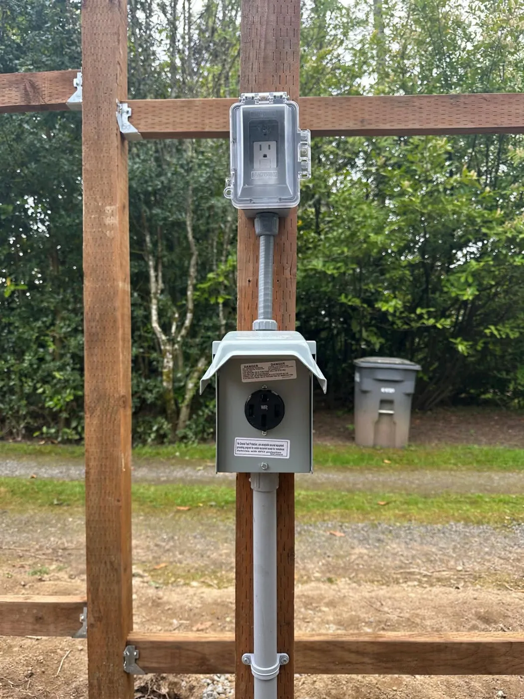 Outdoor 50-amp receptacle and weatherproof GFCI outlet mounted on a post