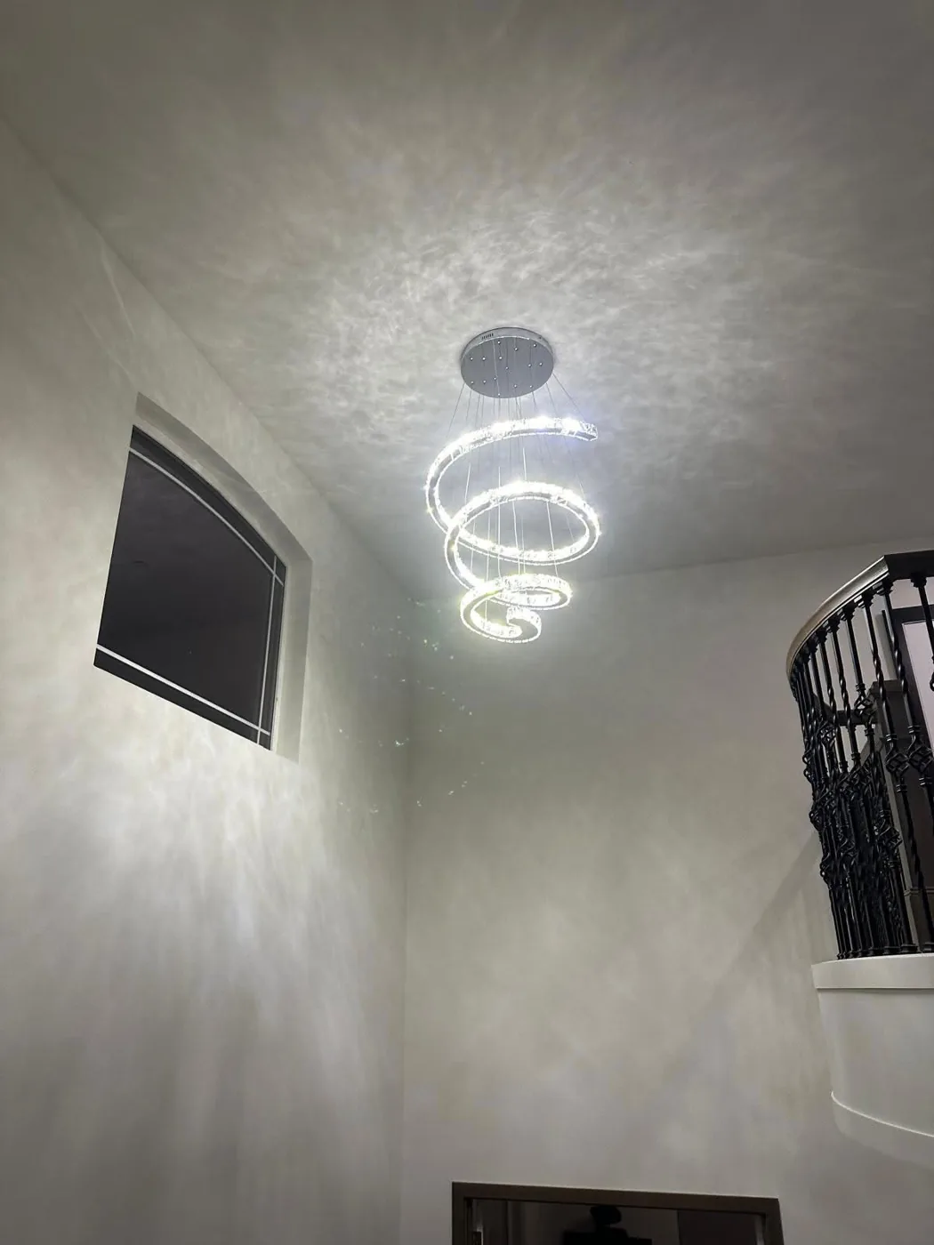 Spiral crystal LED chandelier installed in a two-storey entry